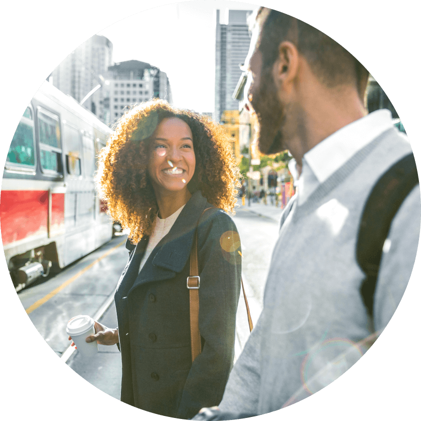 Two Toronto residents walk on a sunny street making their way to a streetcar.